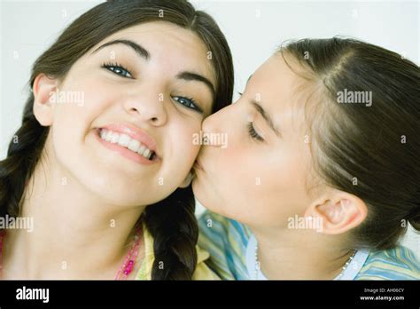 Two Young Female Friends One Kissing The Other On The