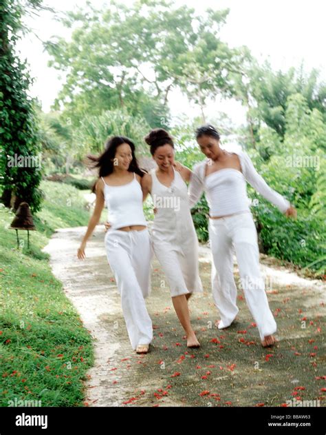Three Women Wearing White Strolling Down Path Stock Photo Alamy