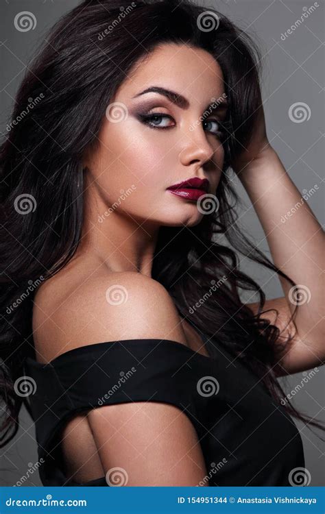 beautiful bright makeup woman with long black curly hair style burgundy lipstick with vamp look