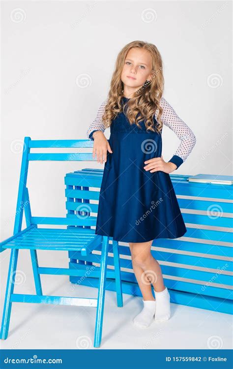 Cute Girl With Blond Curly Hair In School Fashion Clothes With Blue