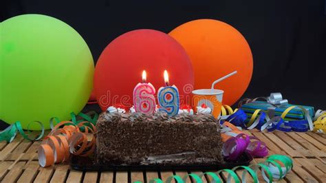 Chocolate Birthday 69 Cake With Candles Burning On Rustic Wooden Table