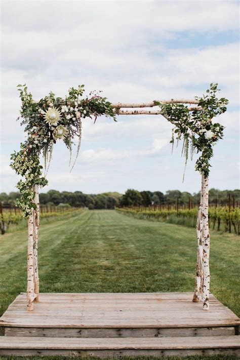 An Outdoor Wedding Ceremony Setup With Flowers And Greenery On The
