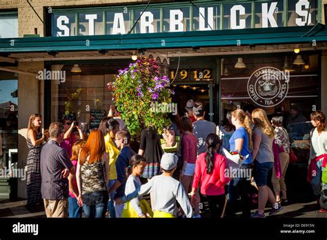 Crowd Of People Surrounding The Original Starbucks Coffee Shop At Stock