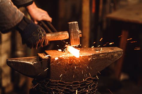 The Blacksmith Manually Forging The Redhot Metal On The Anvil In Smithy