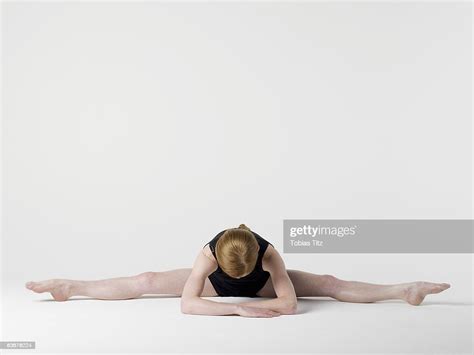 A Young Woman Practicing The Spread Leg Forward Fold Yoga Pose Photo