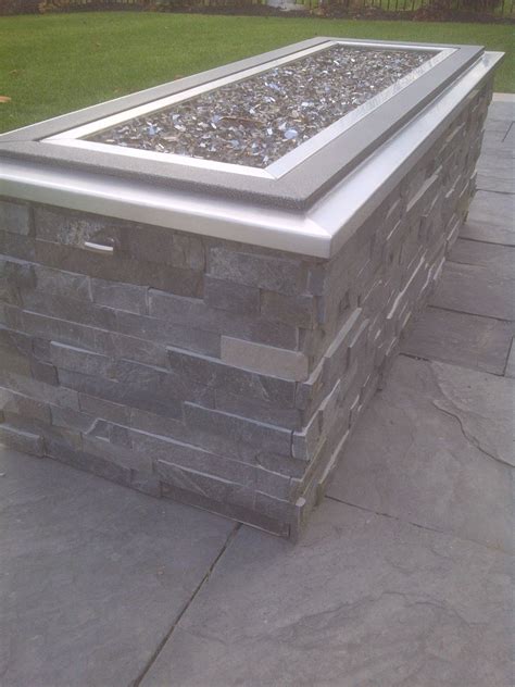 Raised Gas Fire Pit With Crushed Glass Stone Cladding And Stainless Steel Cap Glass Fire Pit