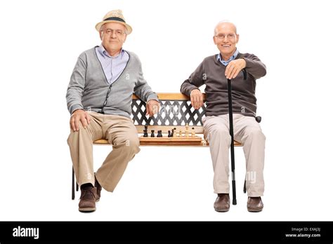 Two Old Men Posing Seated On A Wooden Bench With A Chessboard Between