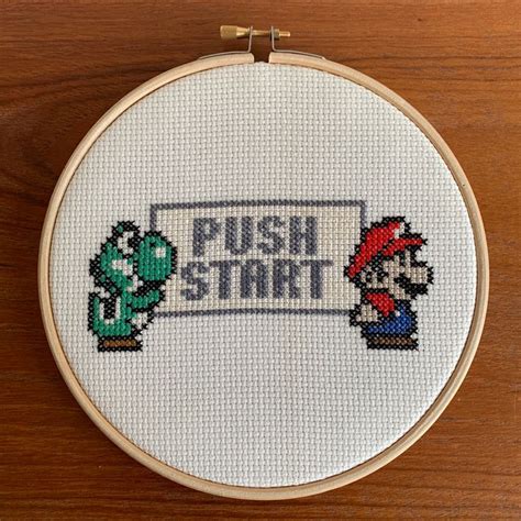 A Cross Stitch Pattern With The Words Push Start And Mario Bros On It