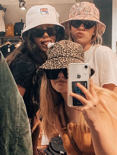 Three Women Wearing Hats And Sunglasses Taking A Selfie With Their Cell
