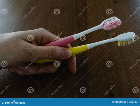 A Woman`s Hand Holds Two Toothbrushes Stock Image Image Of Background
