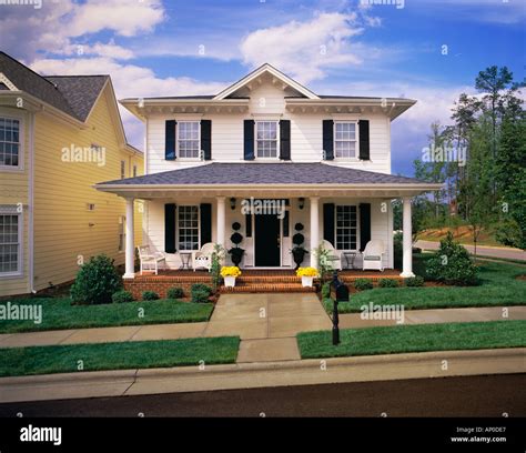 Small Two Story White House With Black Shutters Brick Porch Stock Photo