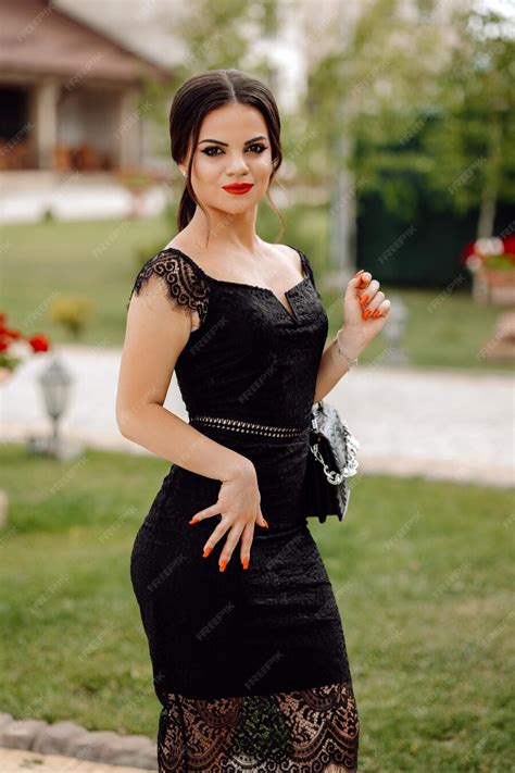 Premium Photo A Woman In A Black Dress Stands In A Garden