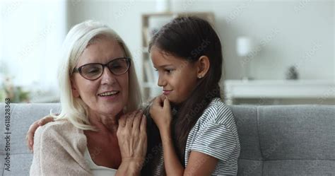 pretty 10s granddaughter spend weekend time with old attractive granny sitting on couch girl