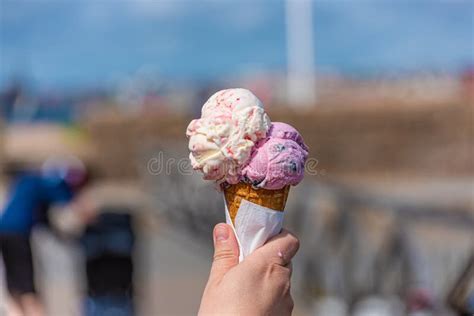 Pink And White Ice Cream In A Cone Melting In The Sun Stock Photo
