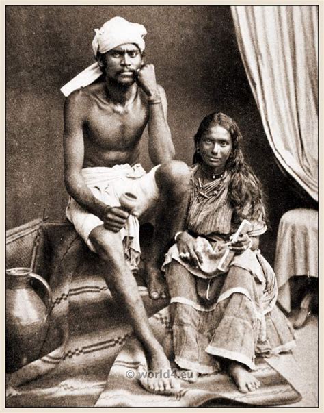 an old black and white photo of a man sitting next to a woman on a bed