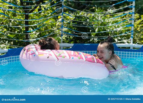 Kids Enjoy Swimming And Floating In Leisure Pool During Summer Vacation