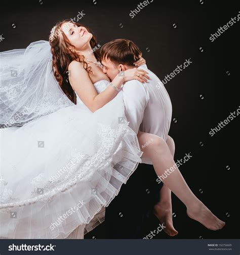 Groom Holds His Bride In His Arms And Kisses Her Breasts Bride And Groom Portrait In Studio