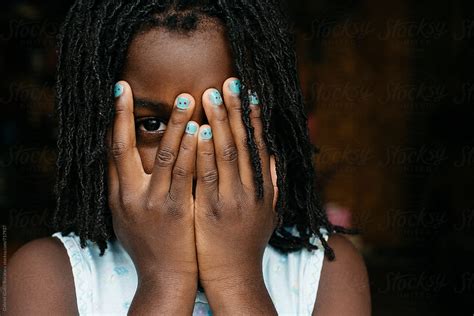 African American Girl Peeking Behind Her Hands Del Colaborador De Stocksy Gabi Bucataru