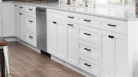 Kitchen cabinets with white countertop black handles and tile backsplash. Kitchen Cabinets | Kitchens | HighCraft Cabinets — Ferndale, WA