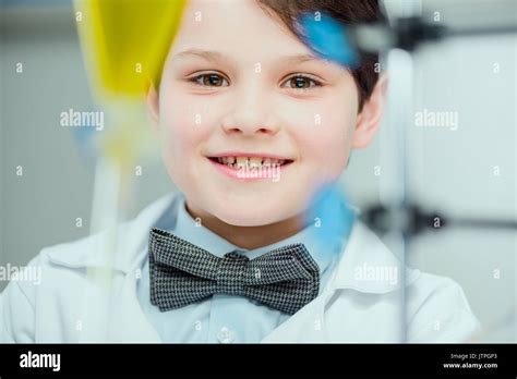 Close Up Portrait Of Cute Smiling Schoolboy In Lab Coat Looking At