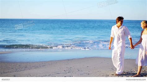 Couple Holding Hands While Walking Along The Beach Stock Video Footage 4569351