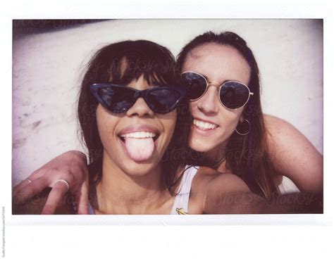 Two Girlfriends Showing Tongue Resting On Beach By Stocksy Contributor Guille Faingold