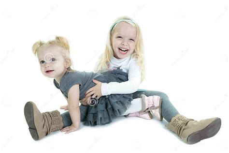 two cute little blond sisters kneeling on the stock image image of playful companions 57817897