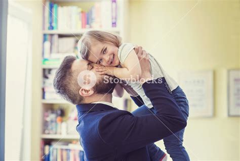 Young Father Hugging His Daughter As He Gets Home From Work Royalty