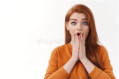 wow gosh look at that impressed entertained pretty redhead female in orange sweater open mouth