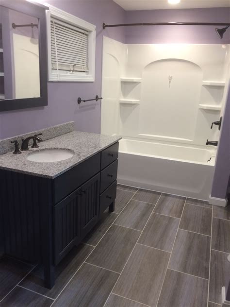 Hexagonal tile on the floor and bath, brick tile around the bath, and blue patterned mosaic around the sink could be overwhelming, but it isn't. Basic Bathroom Remodel | NH Bath Builders