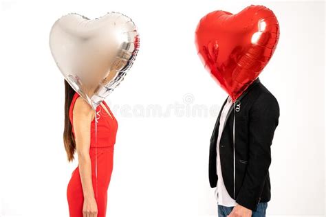 Elegant Couple Stands Against Each Other Covering Their Faces With