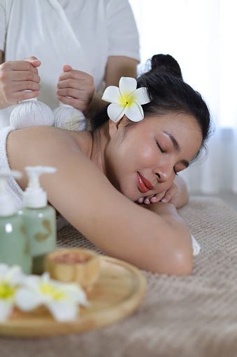 Woman Enjoying Herbal Massage Relaxed Asian Girl Sleeping With Eyes Closed Receiving Traditional