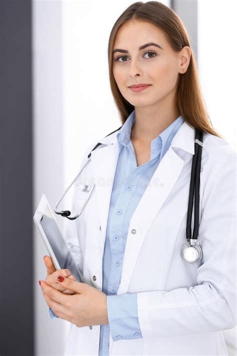 Doctor Woman Using Tablet Computer While Standing Straight Near Window