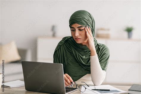 Unhappy Young Arab Female Freelancer In Hijab Feeling Tired Of Working