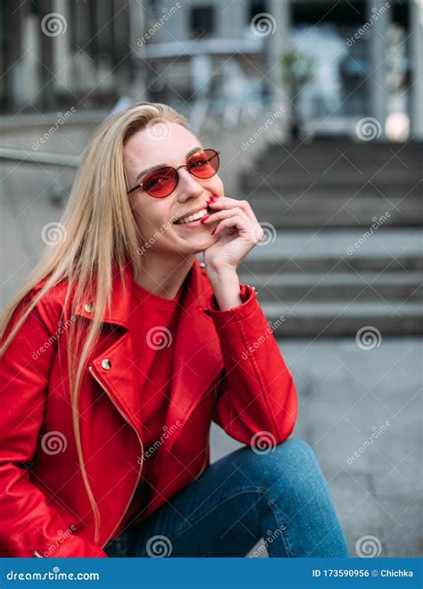 Милая девушка в модном красной кожаной куртке глядя на камеру Стоковое