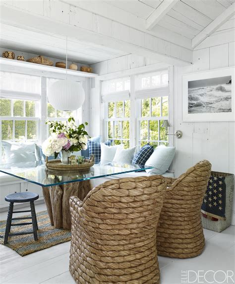 A beautiful coastal living room in white, with a u shaped sofa, grey chairs, printed pillows and jute and wood touches. HOUSE TOUR: From The Mountains To The Beach, A Fashion ...