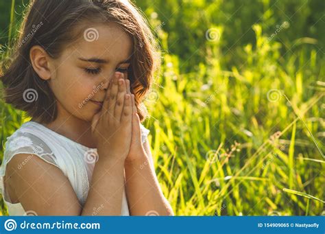 Little Girl Closed Her Eyes Praying In A Field During