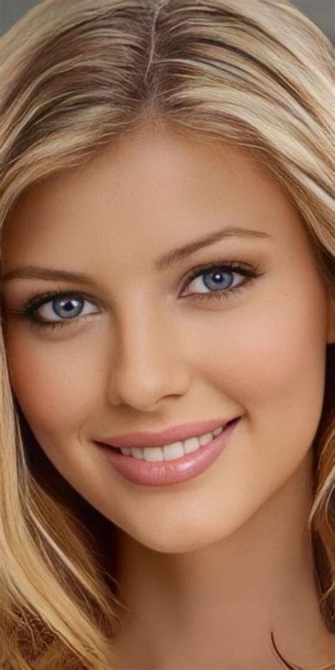 a beautiful blond woman with blue eyes and blonde hair smiling at the camera she is wearing
