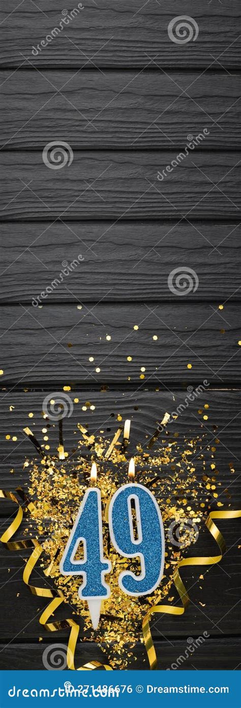 Number 49 Blue Celebration Candle And Gold Confetti On Dark Wooden