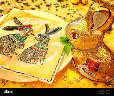 Chocolate Easter Bunny Wrapped In Gold Foil Paper Peering Down A Paper
