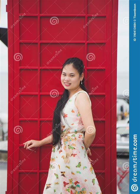 Close Up Portrait Long Hair Asian Woman In A Sweet Beige Long Dress Standing Next To A Red