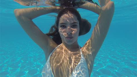 Beautiful Girl In A White Bikini Swimming In The Pool