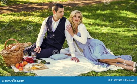 Playful Couple Having Picnic In Park Couple Cuddling Relaxing At Green Meadow With Picnic