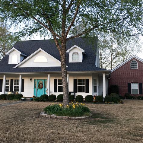 We personally love a black front door with large panes of glass and wood shutters. Turquoise Door - Bold Turquoise Color on the Front Porch - The Gifted Gabber
