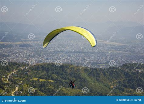 A Aerial View Of Paragliders Tandem On Yellow Blue Parachute Fly Over