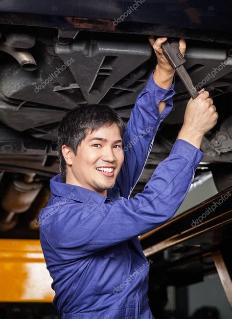 Happy Mechanic Working Underneath Lifted Car Stock Photo By ©simplefoto