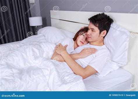 Happy Young Attractive Couple Hugging On Bed In Bedroom Stock Photo