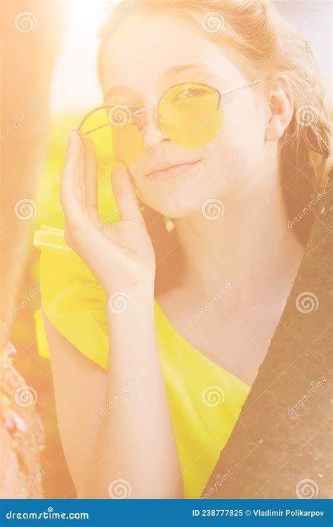 Redhead Girl In A Yellow Dress And Yellow Glasses In The Park In Summer