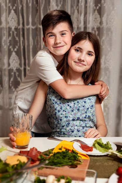 Free Photo Brother And Sister Embraced At Dinner Table