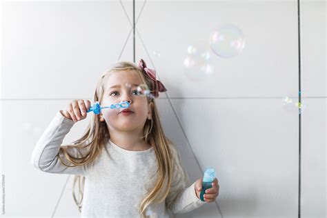 girl blowing air bubbles by stocksy contributor lumina stocksy